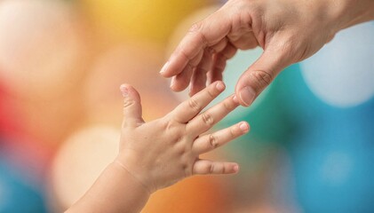 Fototapeta premium Tender Moment: Parent's Hand Reaches for Child's Hand with Bokeh Background, Symbolizing Connection, Care, and Support in a Loving Gesture