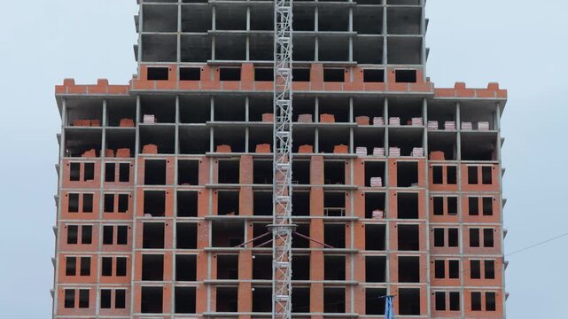 Unfinished residential building facade with construction crane