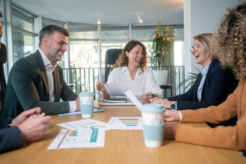 Fototapeta premium Happy multicultural colleagues in business meeting after achieving success