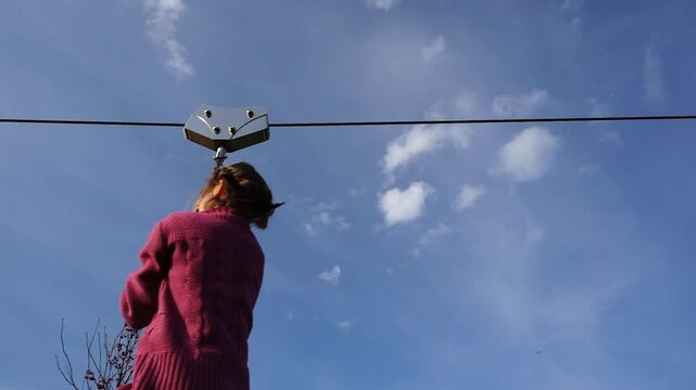 Little beautiful girl is riding zipline