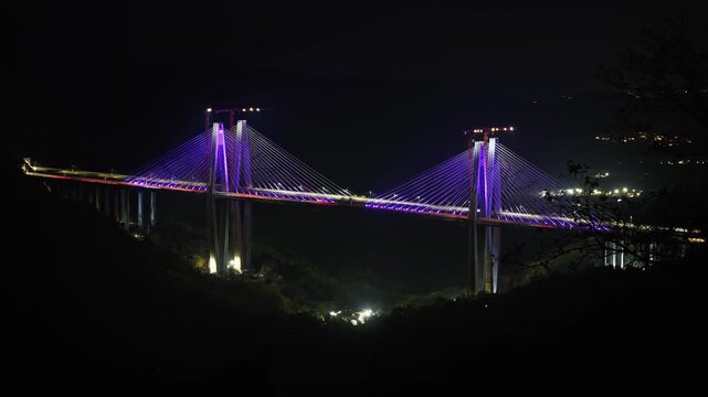Night long exposure timelapse of the Mumbai&ndash;Pune Missing Link bridge on the expressway, capturing continuous streams of vehicle light trails across the elevated highway.
