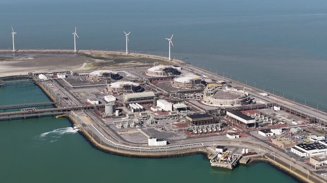 Aerial view of lng terminal and coastal wind turbines