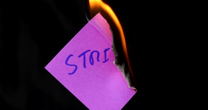 Purple post it note with strike text burning on black background symbolizing the end of labor protests and industrial conflict now.