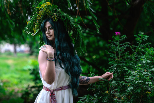 Rusalka in white with a wreath on her head and green hair