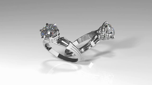 Rotation of white gold rings with shiny diamonds and prong swirl design. 3d animation on white background loop
