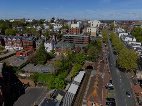 Aerial view of Tunbridge Wells town with train station. Above railway tracks with tunnel and the road leading into town center. Sunny day in popular historic tourist town in Kent, UK.