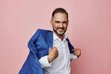 A professional man in a blue suit stands against an isolated pink colored background, exuding confidence, focus, and readiness for success in a corporate setting. © SHOTPRIME STUDIO