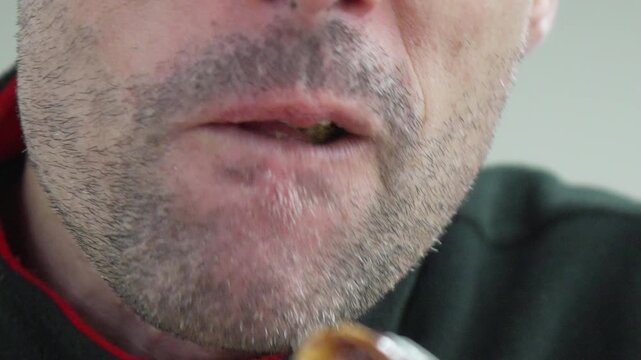 Eating man pastry close up of a middle aged man eating a chocolate dessert and chewing with satisfaction