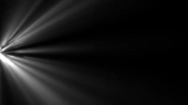 Bright rays of light emerging from a source on a dark backdrop