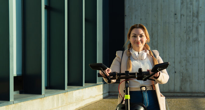 Woman commuter preparing to ride electric scooter