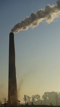 Black smoke is emitted from brick kilns in the early morning light, causing air pollution. Brick kilns emit polluting fumes or hazardous gases like CO2, CO, NOX, NO and SO2.