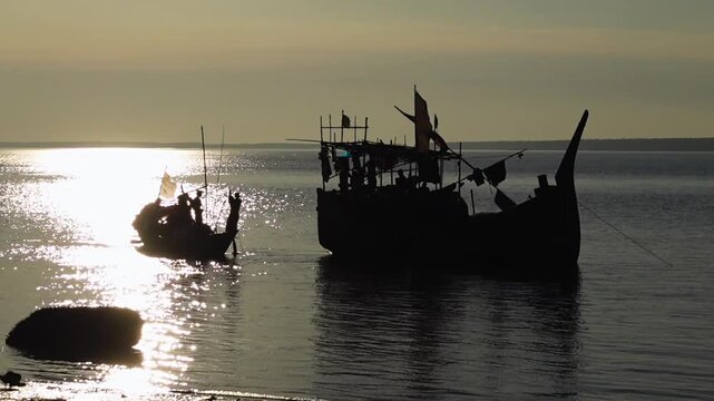 Some fishing boats are seen in action against the sunlight. The river is ebbing and flowing, and the reflections of light on the water are sparkling.