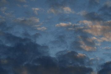 Obraz premium Dramatic summer sunset sky with cumulus clouds, colorful evening light and atmospheric cloudscape.