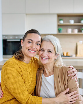 Portrait of mother and daughter  having fun, sitting and hugging  at home, family life, parenting, love and bonding concepts