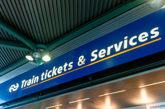 Illuminated train tickets and services sign mounted at Schiphol Airport railway station terminal