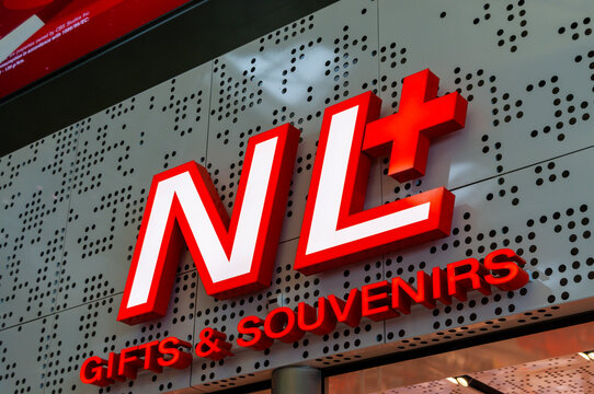 NL+ Gifts & Souvenirs illuminated shop sign and perforated facade at Amsterdam Airport Schiphol