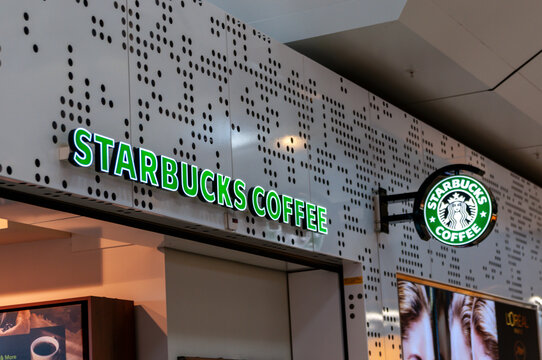 Starbucks Coffee shop sign with green Siren logo and exterior branding on a shop in an indoor mall.