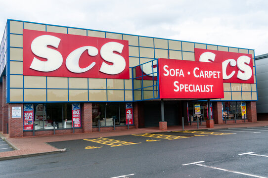 Exterior view of an ScS furniture store situated within a modern UK retail park, showcasing the rebranded "poltronesof&agrave; at ScS" storefront featuring Italian-inspired sofa collections and home furnishi