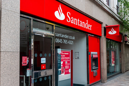 Exterior view of a Santander bank branch, featuring the corporate red signage and branding on a commercial building in a town centre setting in the United Kingdom.