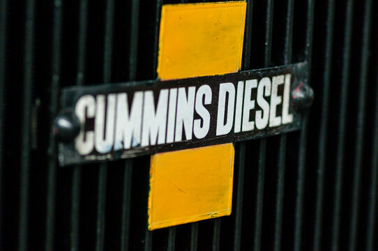 A classic lorry features a prominent chrome Cummins Diesel emblem on its front radiator grille, highlighting the engine's industrial strength and heritage.