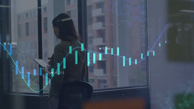 Woman tapping tablet by corner window and animating candlestick overlay while analyzing market data