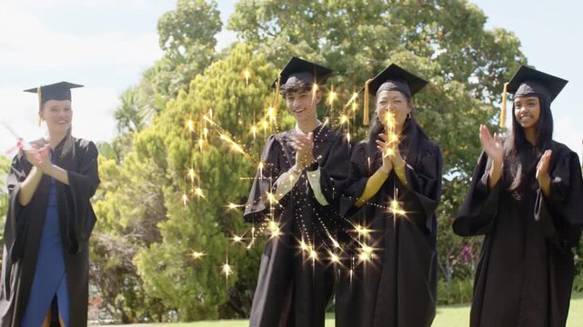 Grads in gowns clapping for graduation, sparkle overlay appearing over center, left raising diploma