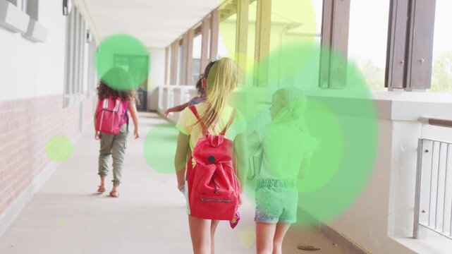 Four pupils walking toward school door movement causing green yellow overlays while carrying bags