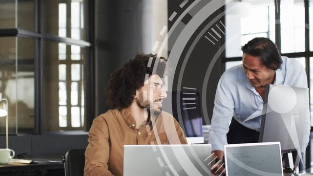 Seated dev typing, pointing, initiating translucent circular UI overlay tech team reviewing screens