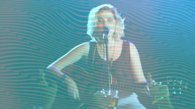 Woman singer starting chord music stage playing guitar singing into mic for crowd with wavy overlay