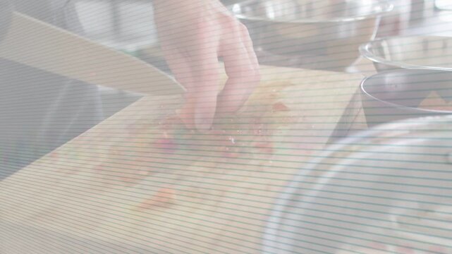 Right hand gripping kitchen knife, cook chopping orange for cooking, arrows guiding into metal bowl