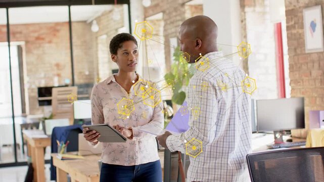 Woman tapping tablet starting tech hex overlay linking them as man holding purple folder reviewing