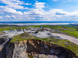 Naklejka premium Granite quarry site with equipment and views of water and landscape taken on a clear day in an open area