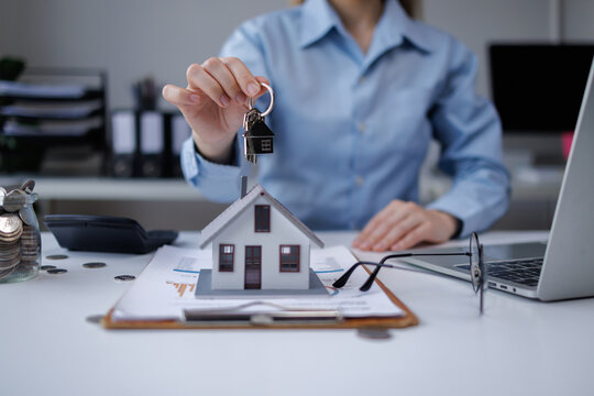 Agent holding house keys, presenting real estate investment