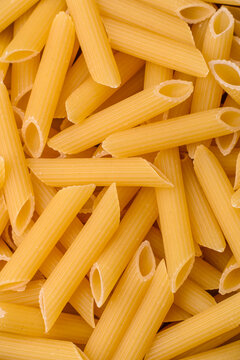 Italian uncooked dry penne regate pasta ready for cooking. Dry penne pasta