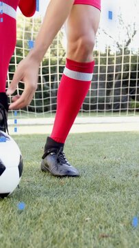 Vertical video: Player tapping ball on pitch, noticing loose lace and tying, blue squares floating