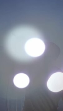 Vertical video: Male singer lifting mic, singing on stage, light flares moving in front for music