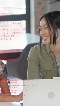 Vertical video: Woman on right turning after red code overlay on laptop, colleague reviewing code