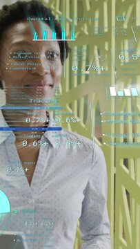 Vertical video: Woman scanning laptop as finance UI appearing and updating charts, confirming gains