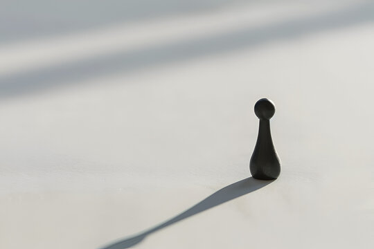 Chess pawn casting long shadow symbolizing leadership burden and isolation