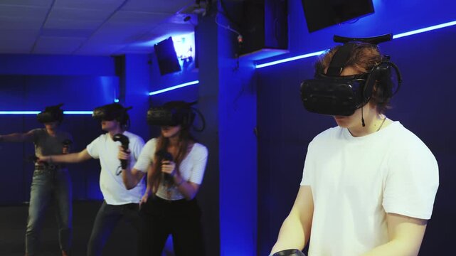 male teenager in virtual reality headset with joystick in hands play network survival game in stone jungle of future. concept of altered reality.Immersive Technologies XR VR AR MR
