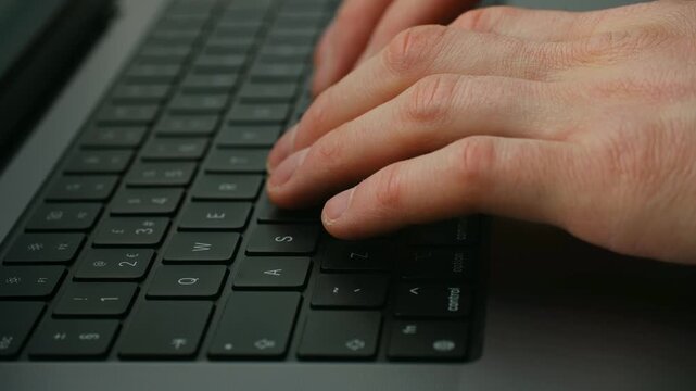 Close up male hands typing on modern laptop keyboard, professional working on computer, coding, writing email or chatting online in business or home office environment Man hands use laptop keyboard
