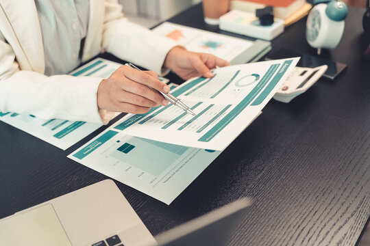 Business professionals are discussing charts and graphs that display successful results in order to analyze financial reports, plan strategies, and improve efficiency.