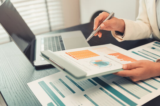 Business professionals are discussing charts and graphs that display successful results in order to analyze financial reports, plan strategies, and improve efficiency.