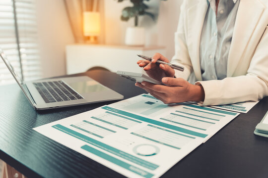 Business professionals are discussing charts and graphs that display successful results in order to analyze financial reports, plan strategies, and improve efficiency.