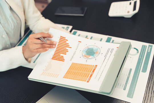 Business professionals are discussing charts and graphs that display successful results in order to analyze financial reports, plan strategies, and improve efficiency.
