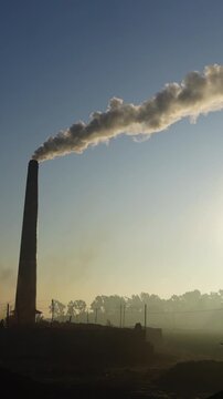 Black smoke is emitted from brick kilns in the early morning light, causing air pollution. Brick kilns emit polluting fumes or hazardous gases like CO2, CO, NOX, NO and SO2.