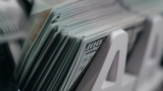 Fast counting of dollar banknotes in automatic machine with focus on movement. Concept financial turnover and liquidity.
