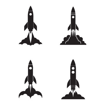 Four black silhouettes of rockets launching into space with smoke and flames  isolated on white background