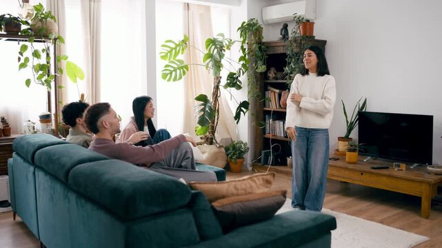 Happy group of friends laughing and having a good time while playing an exciting game of charades in their cozy living room
