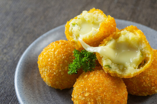 kroket kentang mozzarella, Fried potato croquettes with melted mozzarella cheese filling on a plate served with chili and mayo dip
